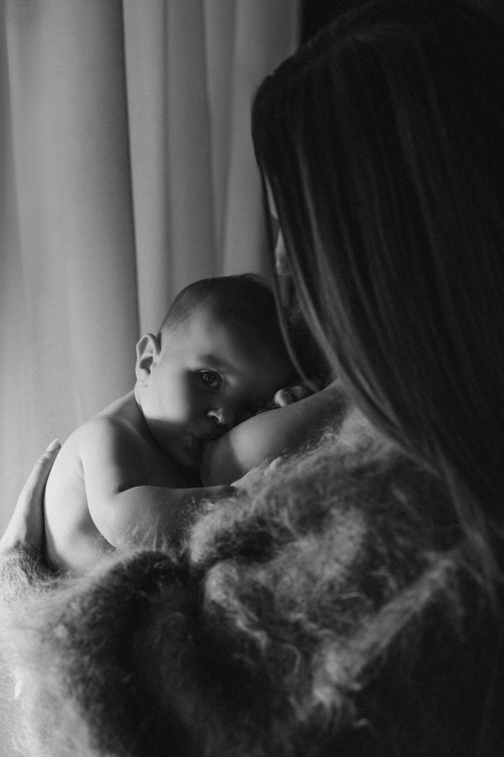 Baby um Aarm vun der Mamm, Géigeliicht um Fënster