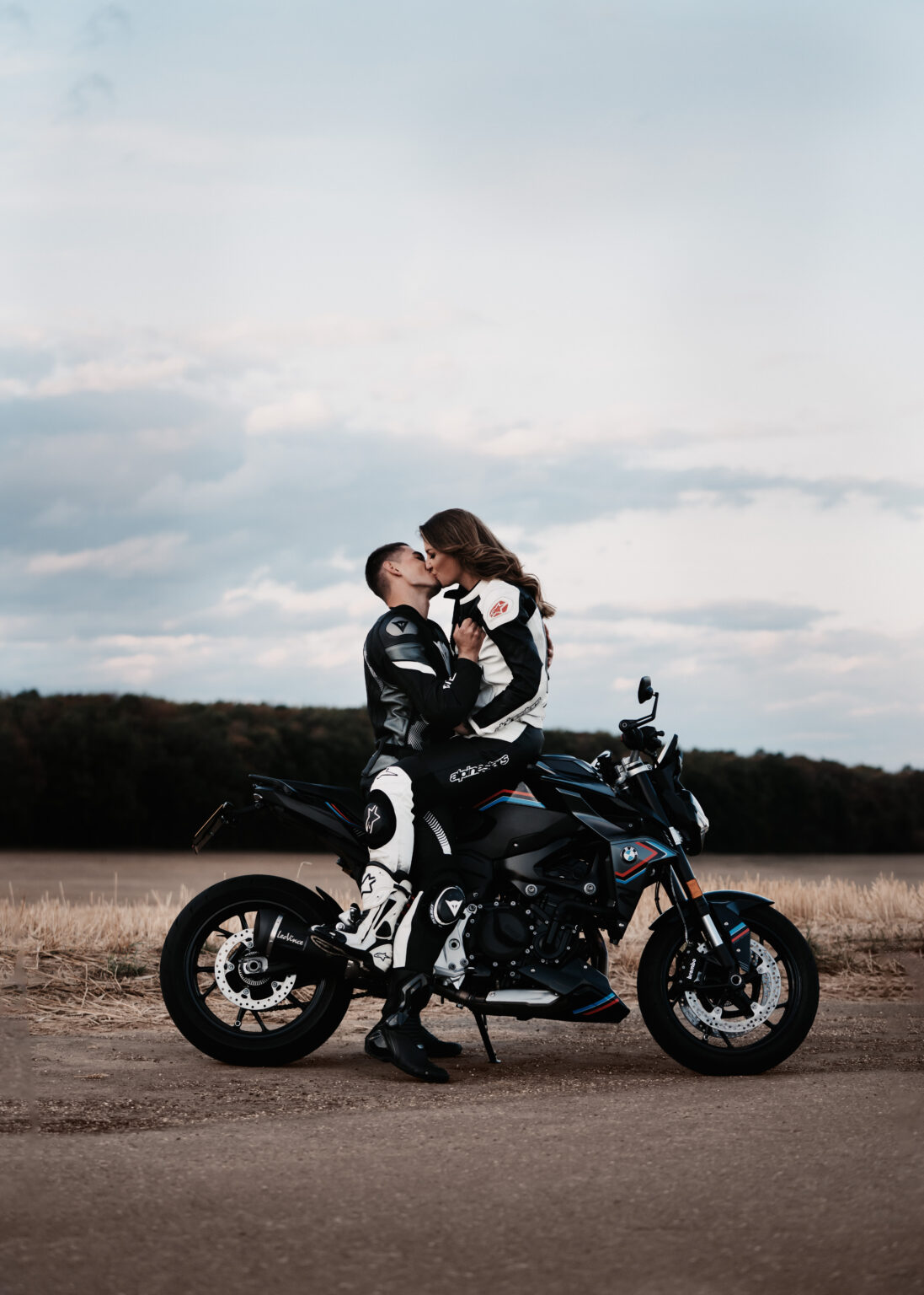 Kuss op der Moto virum Owendhimmel