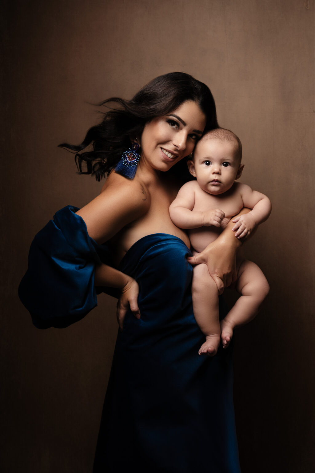 Mamm am bloe Satin-Kleed mam Baby um Aarm